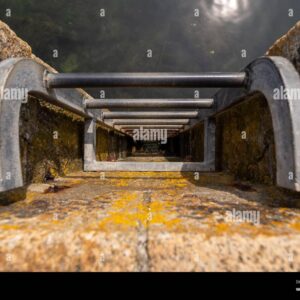 A metal ladder fixed to a stone pier leading down into the water.