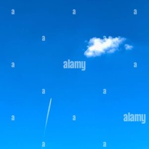 Minimalist blue sky with a single white cloud and an airplane contrail rising upward.